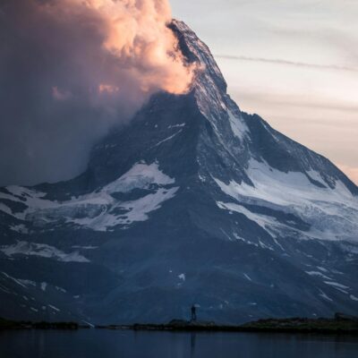 Photo of Person Standing Across the Mountain